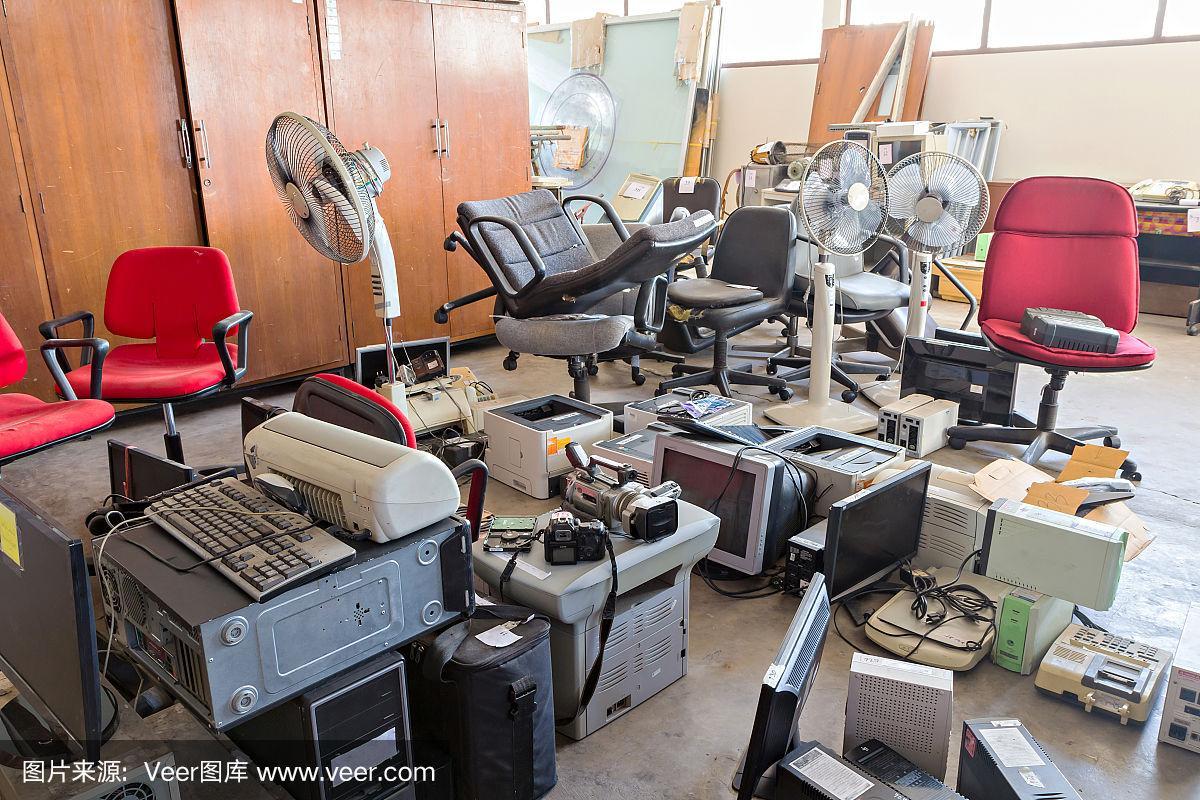 仓库里有破损的办公椅和废弃的电子产品